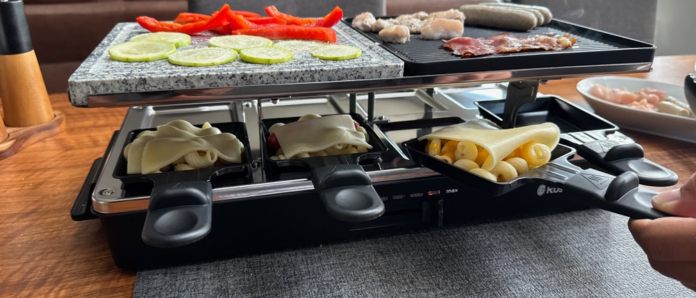 Eine gefüllte Pfanne des Russell Hobbs 26280-56 wird von einer Hand eingeschoben.