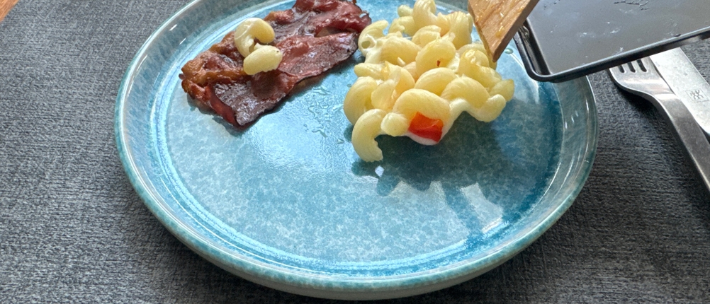 Nudeln überbacken mit Käse liegen nach dem Entfernen aus einer Pfanne des Russell Hobbs 26280-56 auf einem Teller.