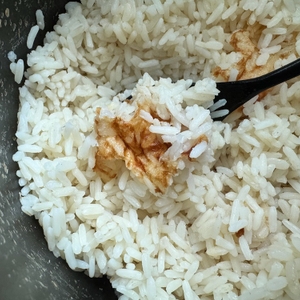 Auf einem Löffel liegt leicht angebrannter Reis aus dem Russell Hobbs 27080-56