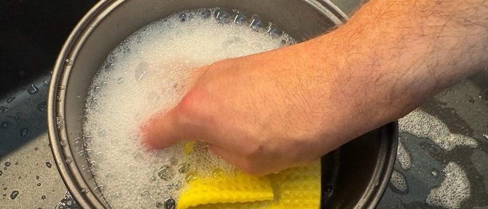 Der Behälter des Russell Hobbs 27080-56 wird von zwei Händen mit einem Lappen und Wasser gereinigt