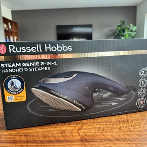 Die Originalverpackung des Russel-Hobbs-Dampfglätters liegt auf einem Wohnzimmertisch