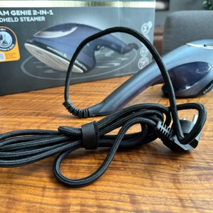 Der ausgepackte Dampfglätter von Russel Hobbs liegt vor seiner Originalverpackung