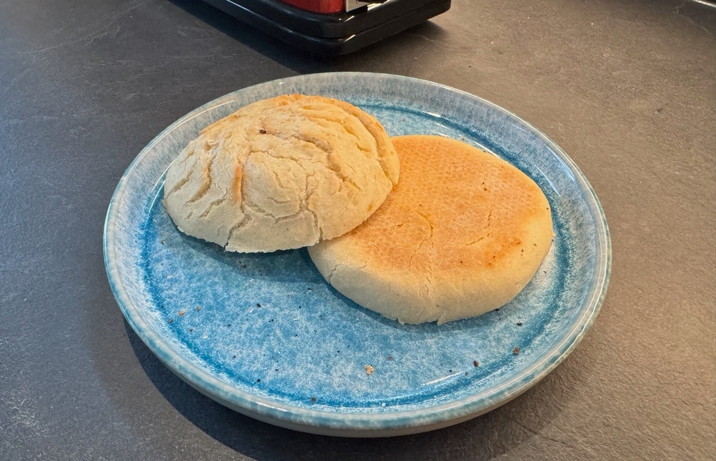 Ein geschnittenes Brötchen liegt auf einem Teller.