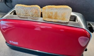 Eine Scheibe Weizentoast und Vollkorntoast stehen nach dem Toasten im Russell Hobbs Colours Flame Red