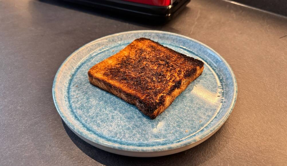 Ein teilweise schwarzes Toast liegt auf einem Teller.