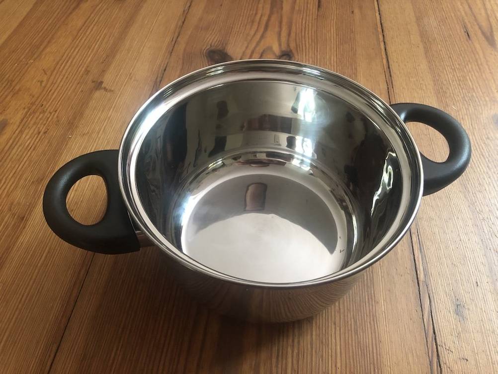 Fondue-Test: Nahaufnahme eines Topfes von Russell Hobbs auf einer Holzfläche. 