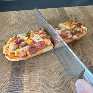 Ein Baguette wird mit einem Messer geschnitten