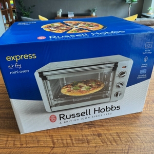 Der Karton des Russell-Hobbs-Minibackofen Express Airfry 5-in-1 26095-56 steht auf einem Tisch