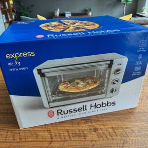 Der Karton des Russell-Hobbs-Minibackofen Express Airfry 5-in-1 26095-56 steht auf einem Tisch
