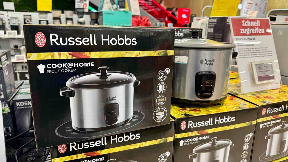 Neben der Originalverpackung steht der getestete Russell-Hobbs-Reiskocher in einem Verkaufsladen.