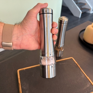 Eine Hand hält die Salzmühle von Russell Hobbs und drückt auf den Auslöser.