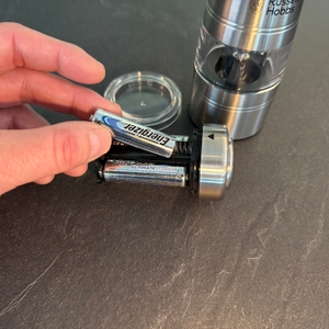 Eine Hand legt eine Batterie in eine der Russell-Hobbs-Salz-und-Pfeffermühlen.