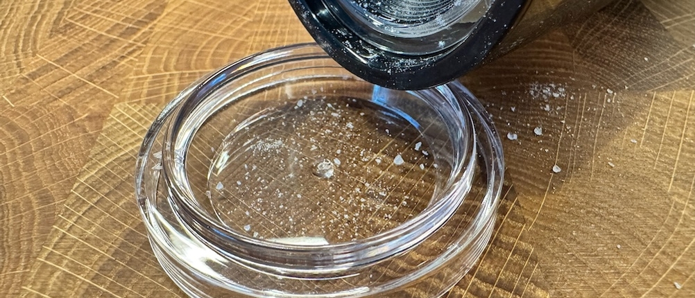 Pfeffer rieselt nach dem Mahlen auf einen Deckel