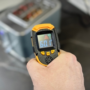 Mit einem Laserthermometer wird die Außentemperatur eines Toasters getestet.