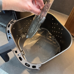 Unterste Ebene wird von einer Hand aus dem Behälter der Russell Hobbs XXL 27170-56 geholt