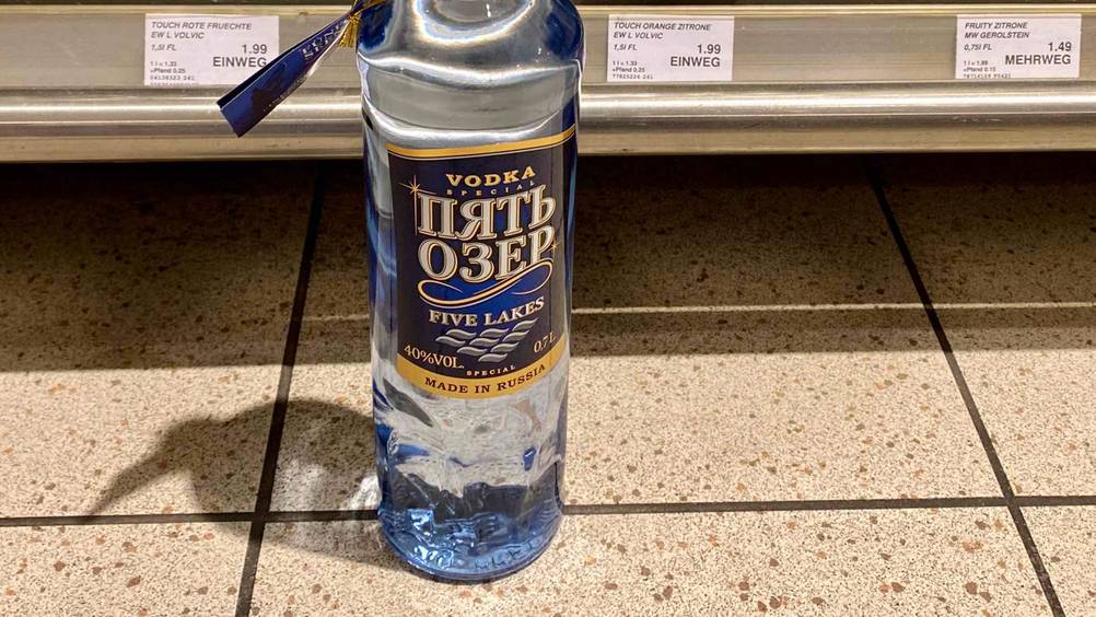 Nahaufnahme des Labels auf der Flasche des getesteten russischen Wodkas vor einem Regal.