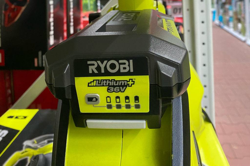 Laubsauger-Test: Detailansicht mit Fokus auf Batterie-Standanzeiger eines gelben Maxpower der Marke Ryobi in einem Verkaufsbereich.