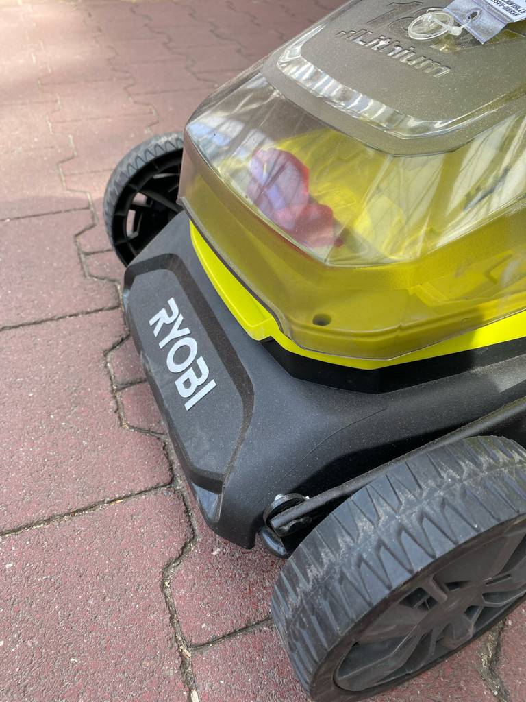 Detailansicht der vorderen Profilräder und der Motoreinheit eines Ryobi-Rasenmähers mit Mulchfunktion im Test.