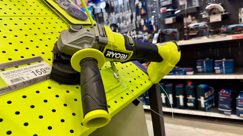 Nahaufnahme des Ryobi-Winkelschleifer im Test auf einer gelben Fläche mit Preisangabe.