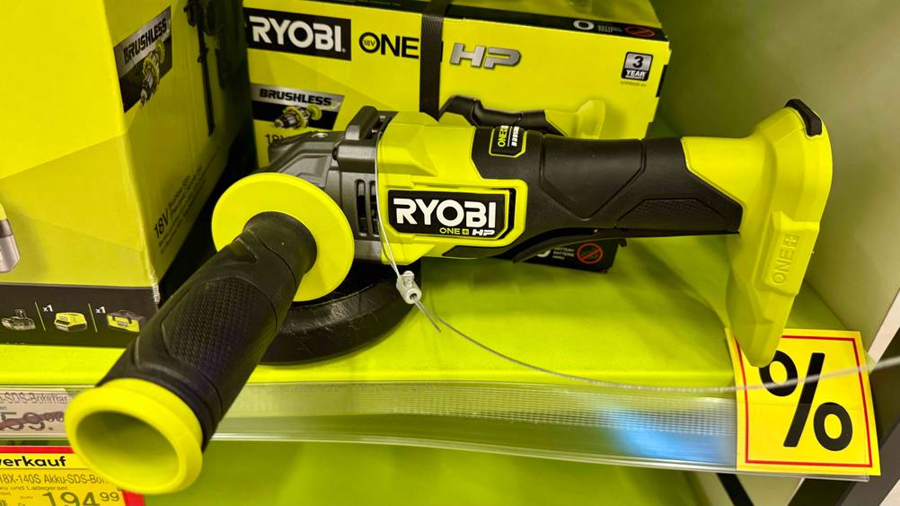 In einem gelben Regal befindet sich der getestete Ryobi-Winkelschleifer.