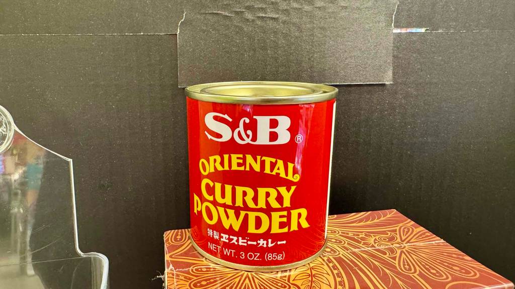 Im Test: Currypulver in einer Dose, die auf einem Karton steht.