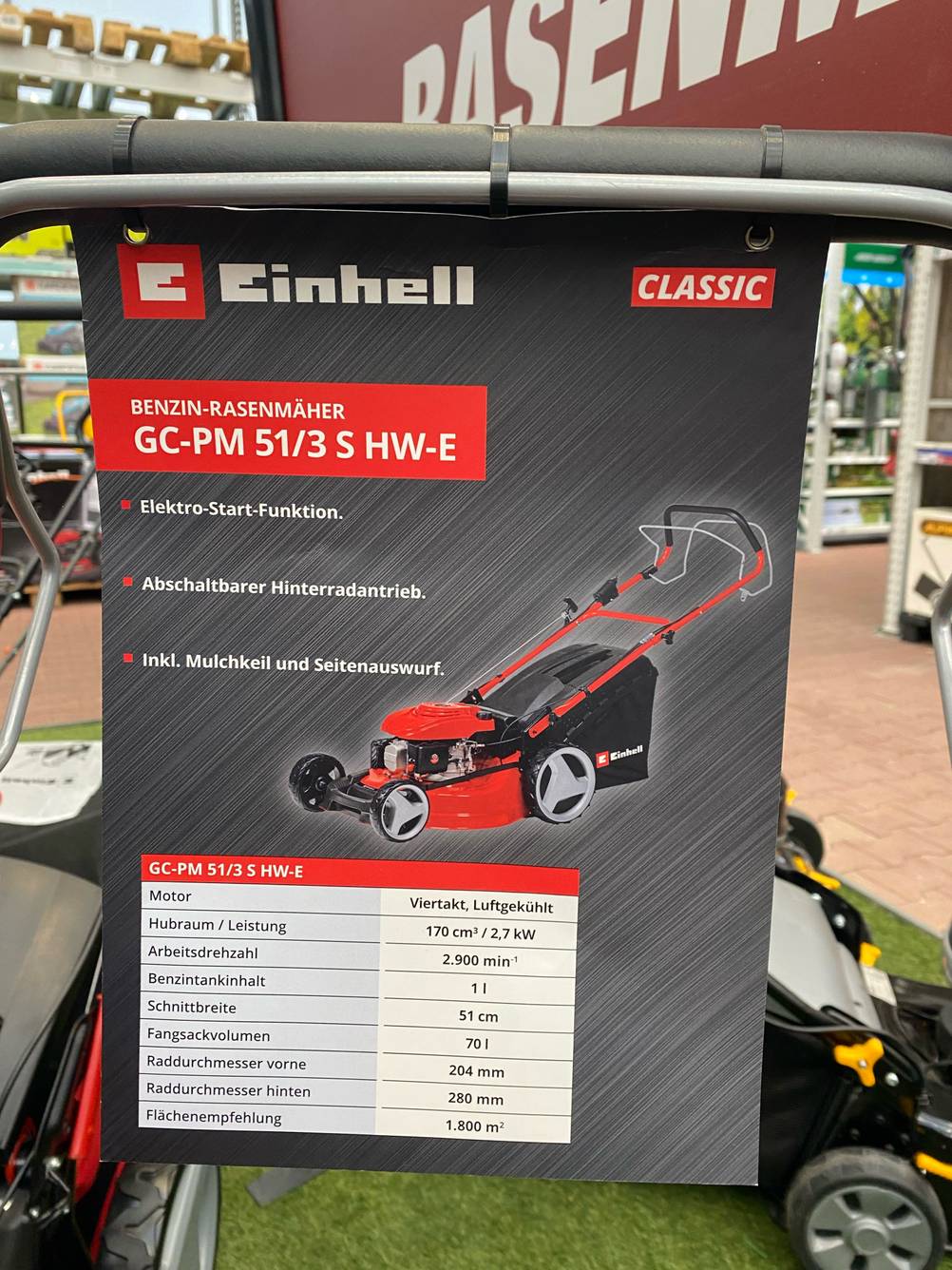 Nahaufnahme eines Plakats mit Produktinformationen eines Einhell Benzin-Rasenmähers mit 51 cm Schnittbreite im Test.