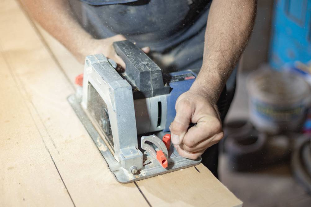 Sägeblatt (160x20) im Test. Eine Person schiebt eine Handkreissäge über ein langes Holzteil.