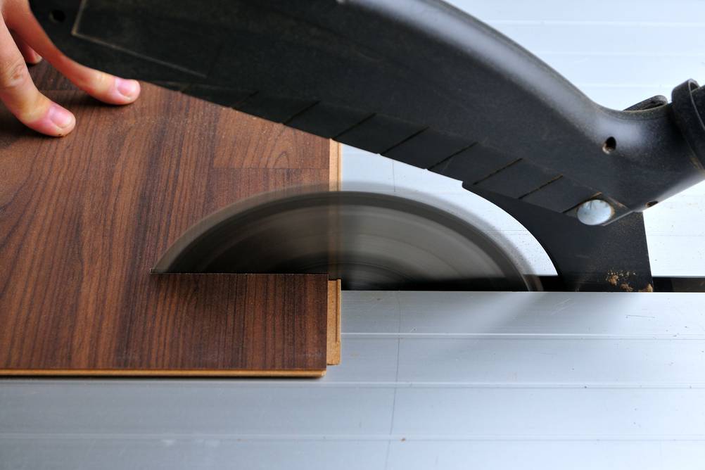 Sägeblatt (160x20) im Test: Ein Laminatbrett wird durch eine Tischkreissäge geführt.