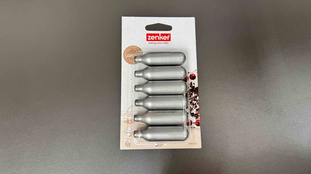 Die getesteten Sahnekapseln auf einer grauen Fläche.