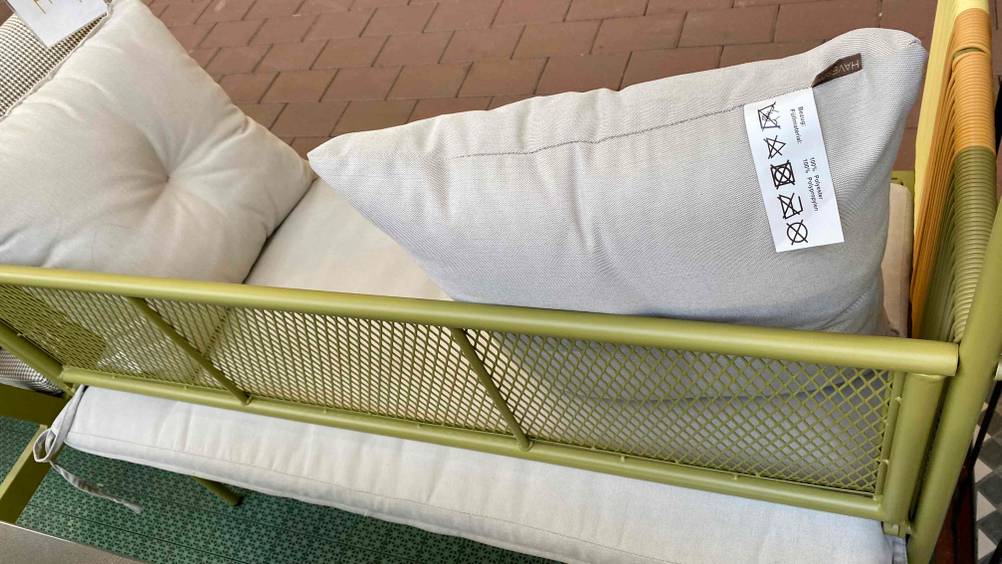 Detailansicht der Gitter-Rückenlehne einer grün-gelb-orangen Gartenbank aus Metall im Test.