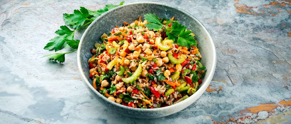 Gemüsezerkleinerer im Test: Schale mit Salat aus Gemüse und Reis steht auf einer Marmorfläche.