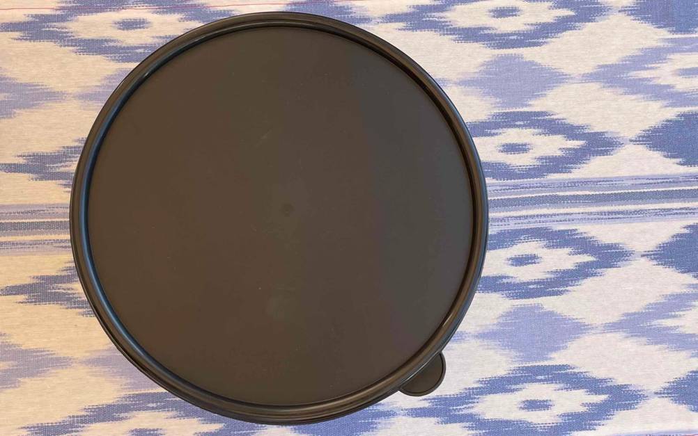 Edelstahl-Salatschleuder getestet: Nahaufnahme des Aromadeckels von oben auf einer weiß-blauen Tischdecke.