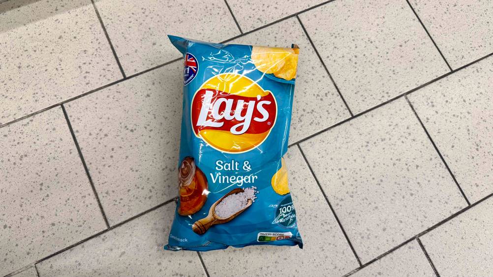 Eine Tüte der Salt-and-Vinegar-Chips von oben auf einem Fließenboden.