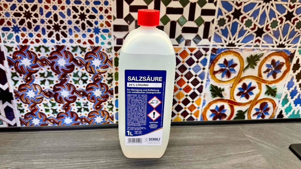 Die Salzsäure im Test steht vor einer bunten Wand.