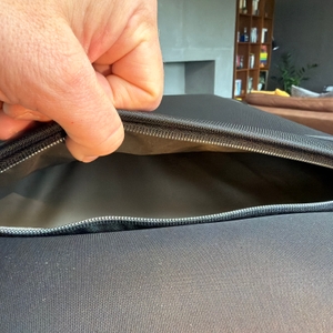 Eine Hand hält ein kleines Fach an der Außenseite vom Samsonite Airea auf