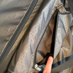 Eine Hand öffnet eine kleine Tasche im Innenraum des Samsonite Flux