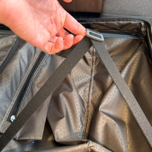 Eine Hand dehnt einen Verschluss an einer Seite vom Innenraum des Samsonite Flux