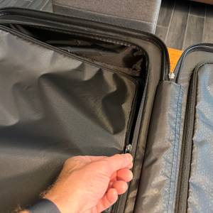 Eine Hand verschließt eine Seite vom Innenraum des Samsonite Neopulse mit einem Reißverschluss
