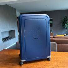 Der Samsonite S'Cure Spinner 75/28 steht auf einem Holztisch.