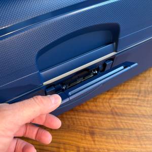 Eine Hand öffnet den Samsonite S'Cure Spinner 75/28.