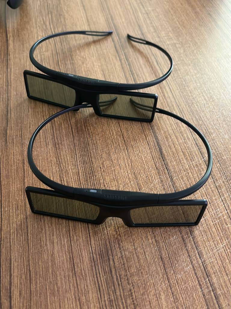 Zwei getestete 3D-Brillen, von oben betrachtet, liegen auf einer Holzoberfläche.