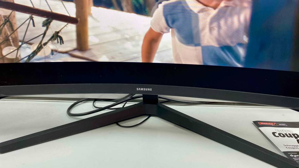 Curved-Gaming-Monitor getestet: Nahaufnahme des unteren Rahmens mit Logo und des Ständers.