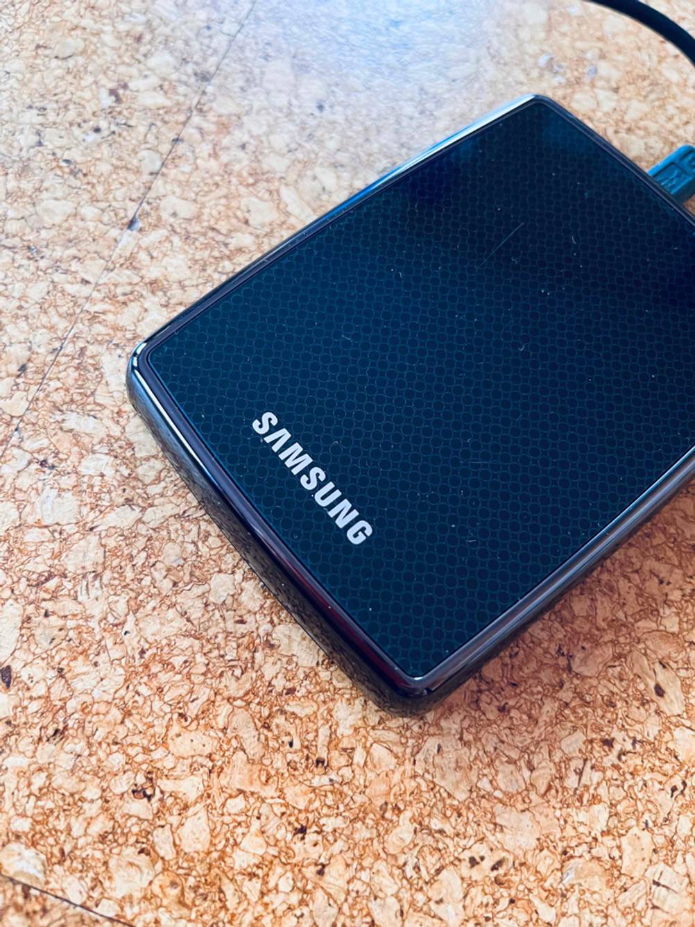 Im Test: externe Festplatte 3-5 Zoll liegt schräg auf einem Korkboden.