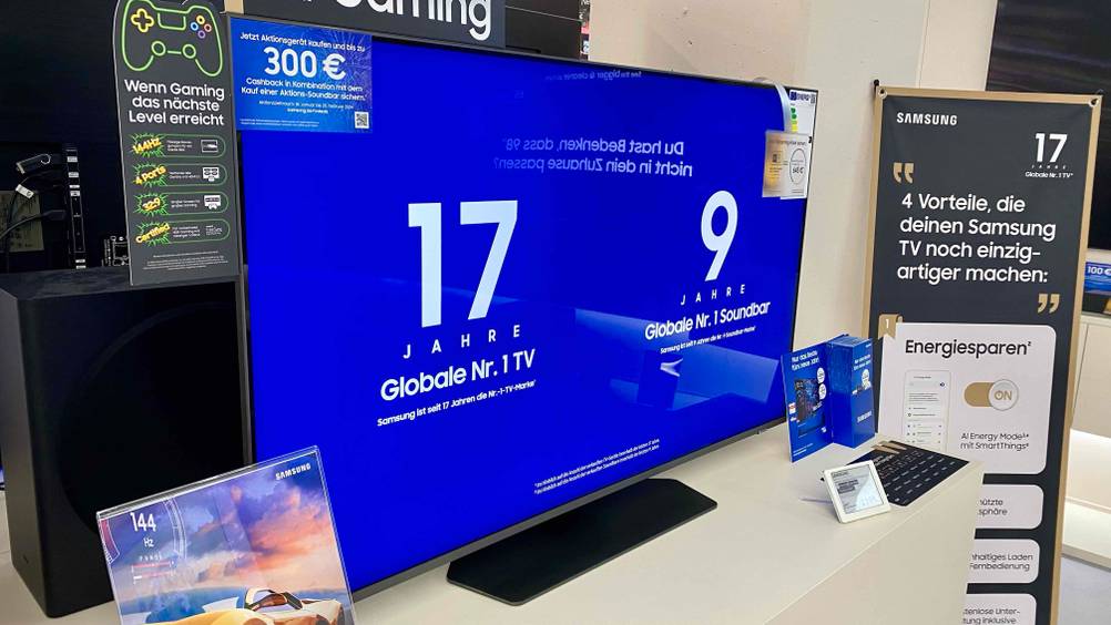 Samsung-Fernseher (50 Zoll)-Test: Ein Gerät mit eingeblendeten Informationen auf einer hellen Fläche in einem Verkaufsraum.