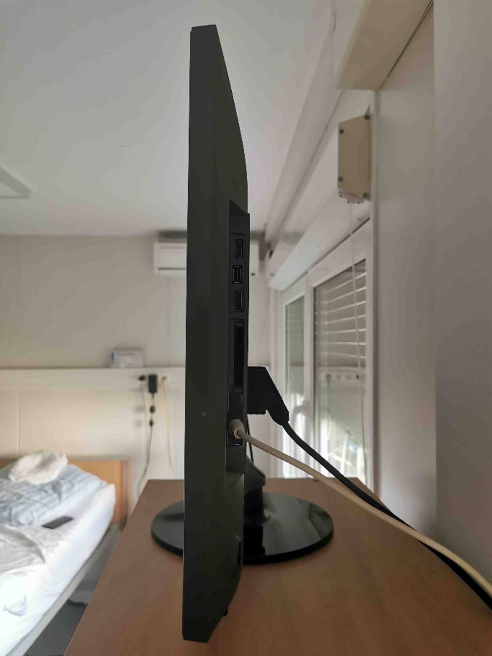 Seitenansicht eines Fernsehers im Test auf einem Regal in einem Schlafzimmer.