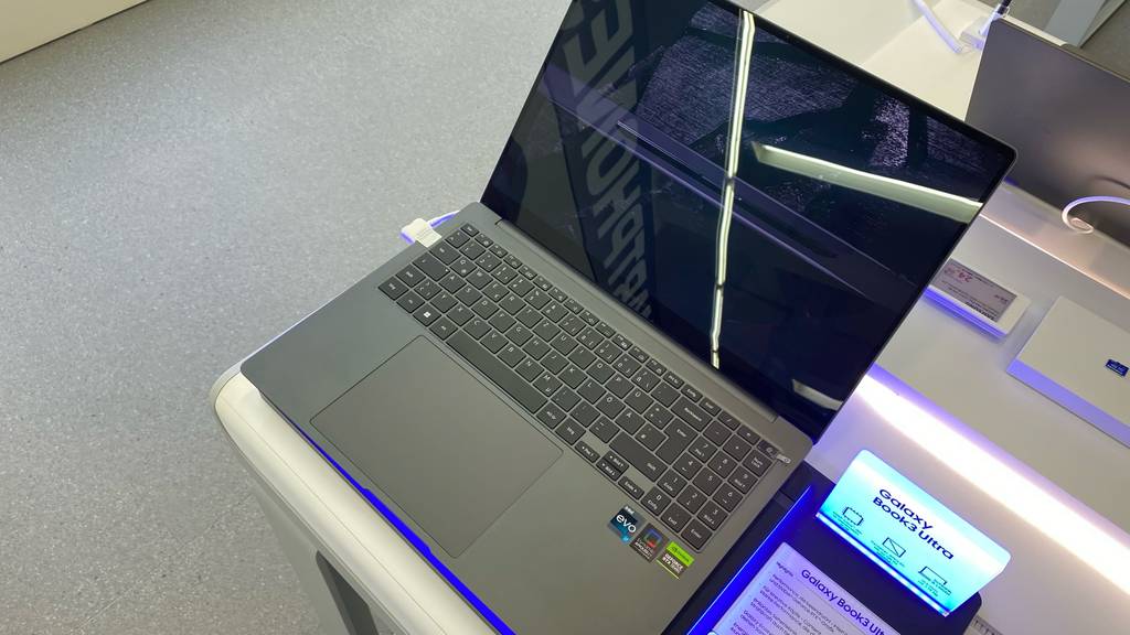 Samsung Galaxy Book im Test: Das Gerät mit befindet sich auf einem Einkaufstisch inklusive Ausstellschild mit Beschreibung.