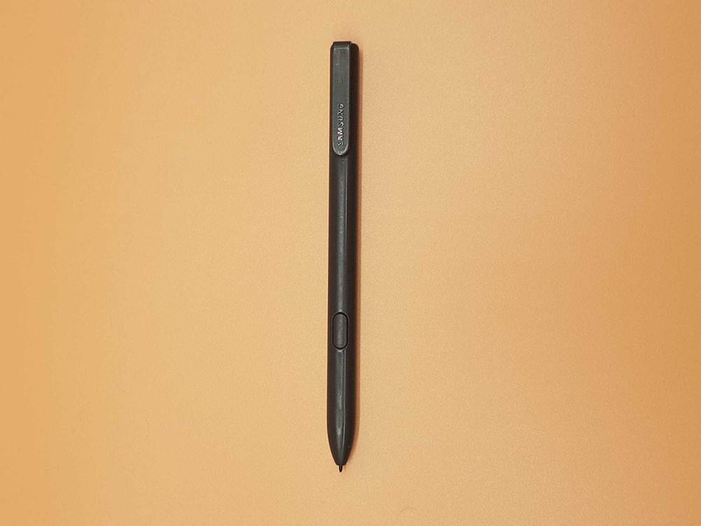 Samsung Galaxy Book getestet: Nahaufnahme des Samsung Stiftes auf einer orangen Fläche.
