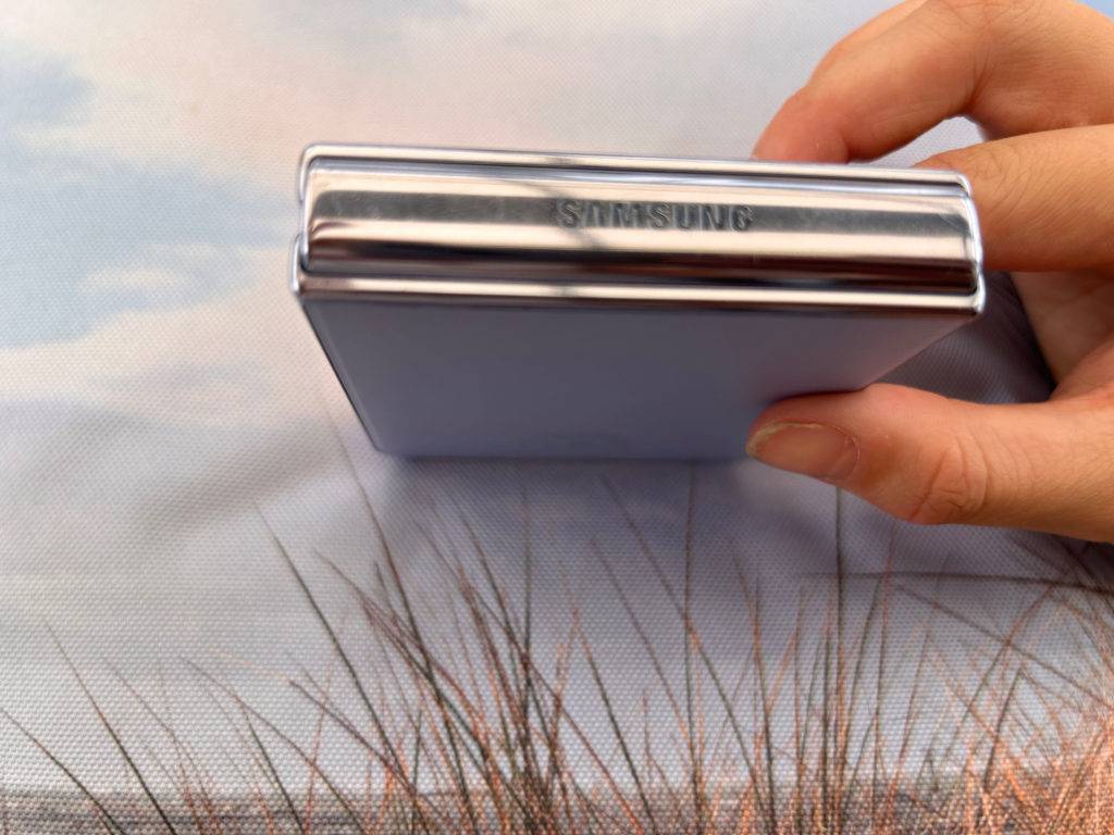 Hand hält ein zusammengeklapptes Samsung Klapphandy
