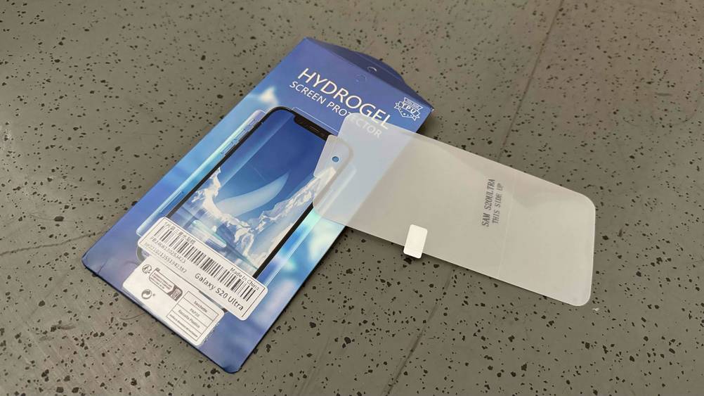 Auf einem grauen Boden liegt eine Samsung-Galaxy-S20-Ultra-Panzerglas im Test leicht über der Verpackung.