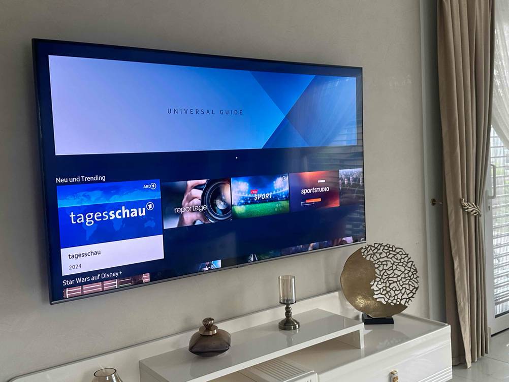 Im Test: Blick auf einen an einer Wand hängenden eingeschalteten 80-Zoll-Fernseher.